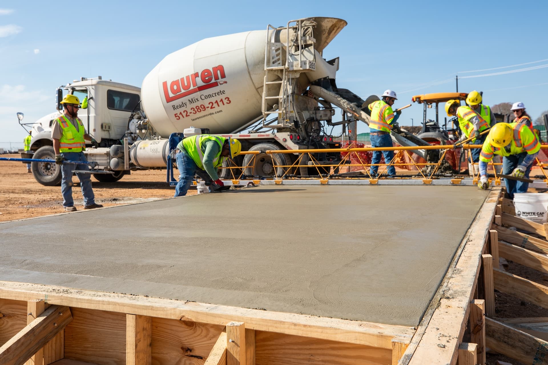 Fresh concrete with a trowel and Lauren Concrete truck in the background