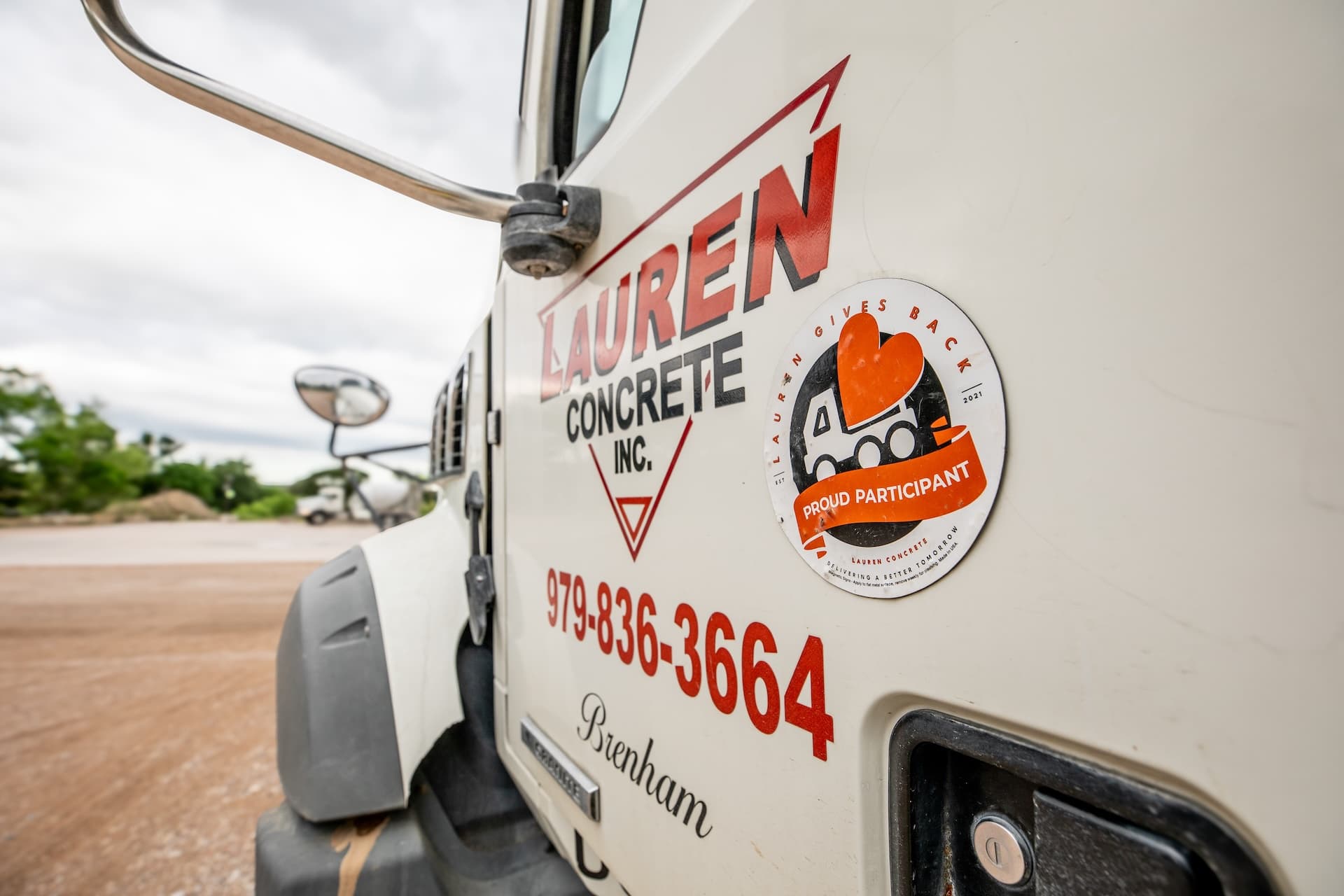 A ready-mix truck with a Lauren Gives Back magnet