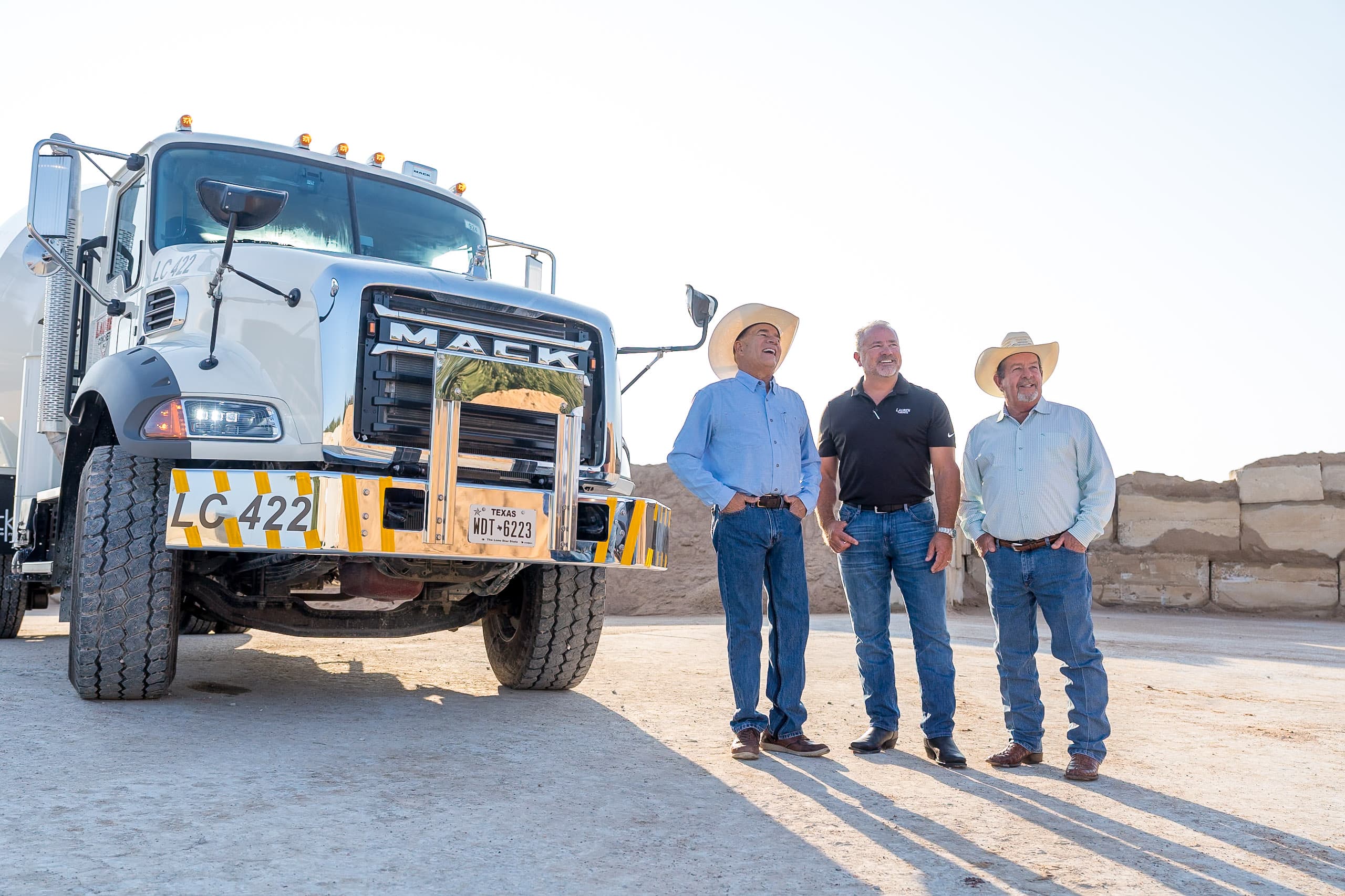 A picture of Ronnie, Ryan and Ray standing in front of a concrete truck