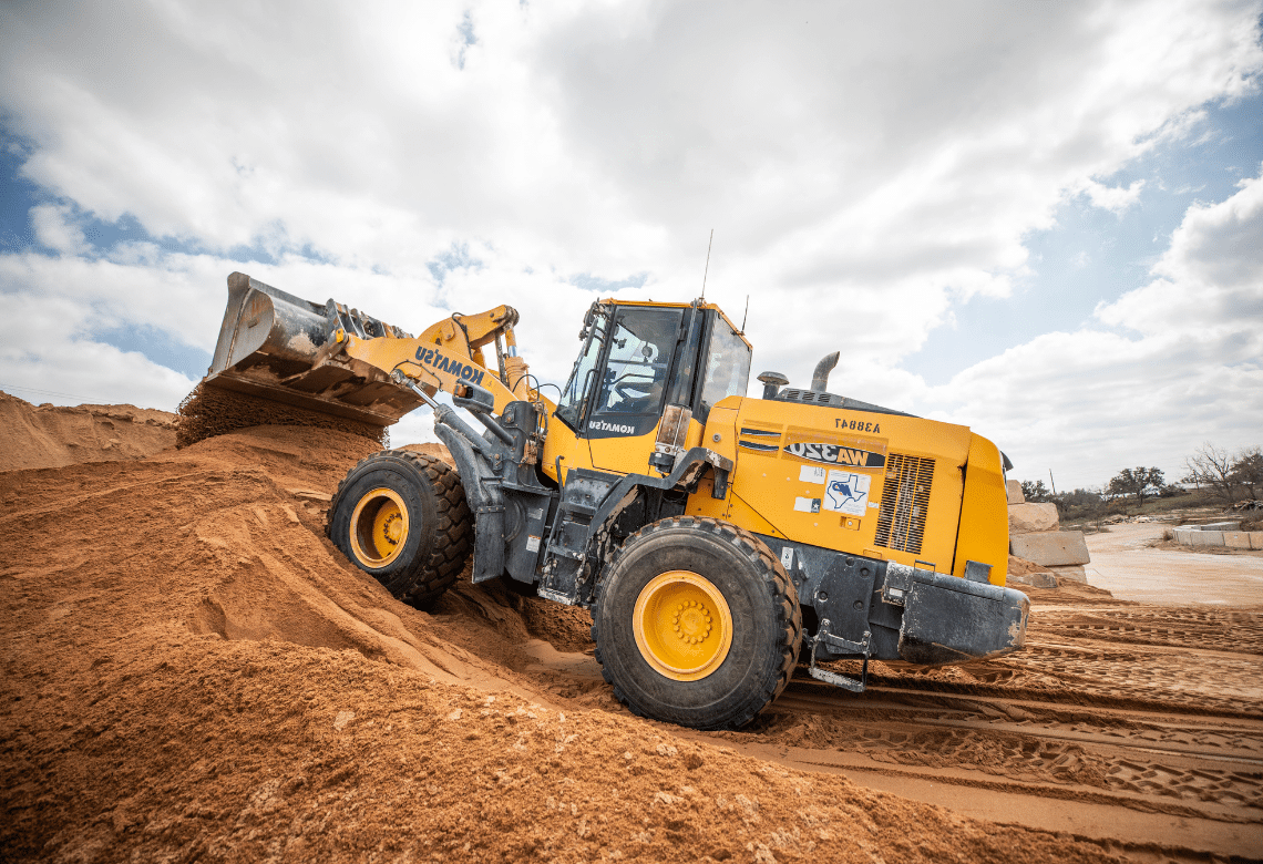 A loader scooping up sand at a Lauren Concrete plant